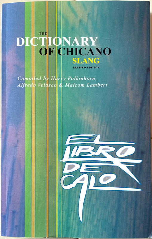Front book cover of ‘El Libro de Caló: The Dictionary of Chicano Slang’ – an authoritative guide containing over 100 pages of Chicano street slang – by Harry Polkinhorn, Ph.D Alfredo Velasco, and Ph.D Malcom Lambert.