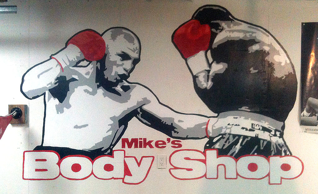 Computer art logo design and mural painting for ‘Mike’s Body Shop’ – a boxing gym in Yuba City, California – featuring two boxers in black-and-white fighting each other with “Mike’s Body Shop” in red and white letters underneath them.