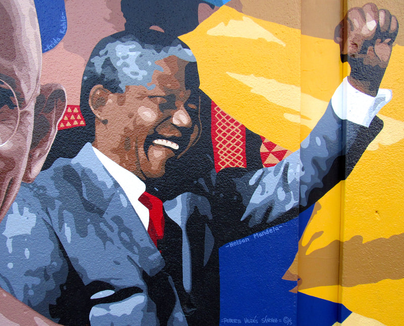 Mural art portrait painting of South African leader and anti-apartheid activist Nelson Mandela, holding his fist up in the air.