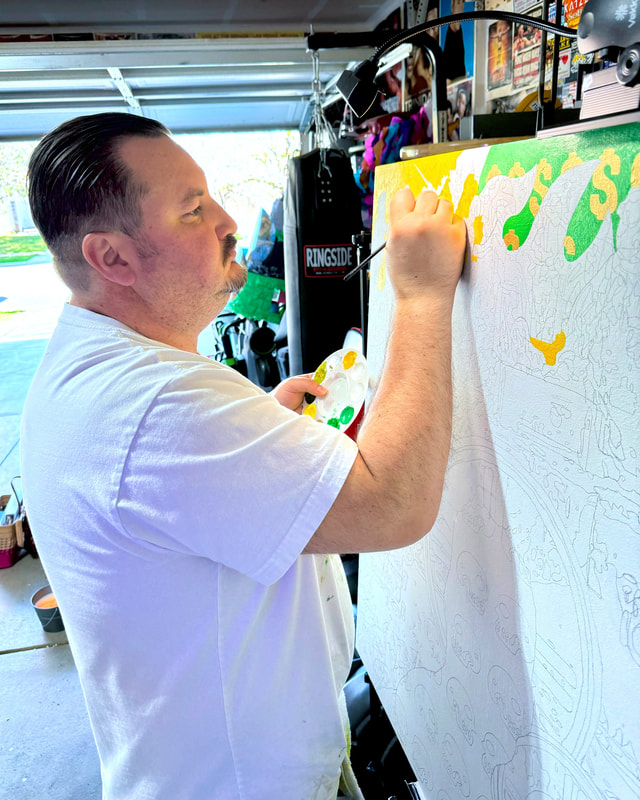 Photo of Chicano artist Roberto Valdes Sanchez painting yellow flames on a large canvas.